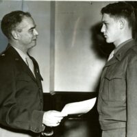 Photo of Pvt. Vernon H. Dalluge receiving commendation from Brig. Gen. Donald F. Fritch